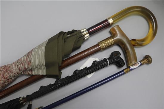Three umbrellas, one with owl handle and a horn handled walking stick